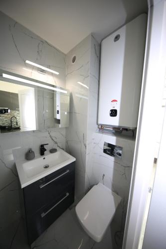Baño blanco con lavabo y aseo en Studio Indecent, en Cap d'Agde