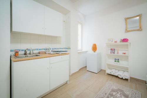 代森扎諾－德爾加達的住宿－Suite "Castello" del Garda - APT per coppie Garda，厨房配有白色橱柜和水槽