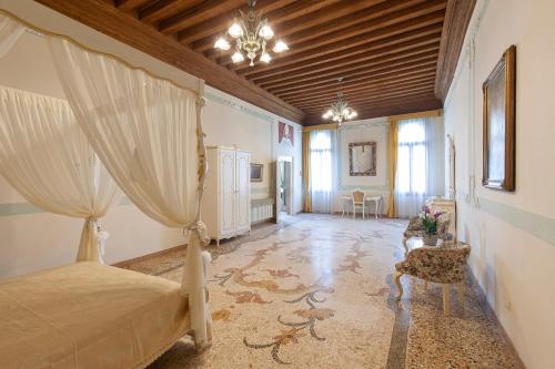 a bedroom with a bed and a chair in a room at LUXURY APARTMENT PESARO PAPAFAVA in Venice
