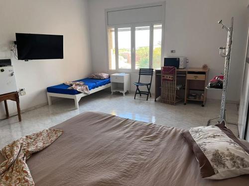 ein Wohnzimmer mit einem Bett und einem TV in der Unterkunft Suite MoonLight zone touristique tozeur in Tozeur