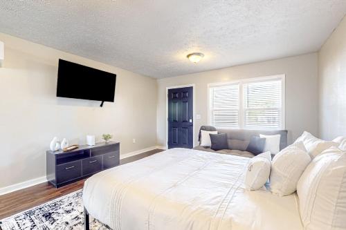 1 dormitorio con 1 cama grande y TV de pantalla plana en Ambry On Central, en La Follette