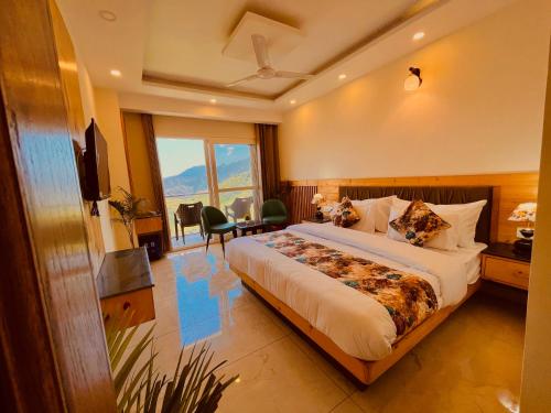 Habitación de hotel con cama grande y TV en Pinerock Resort, Mussoorie ! Luxury Rooms ! Mountain View ! Open Terrace ! Cafe, en Mussoorie