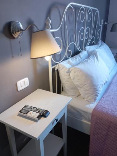 ein Bett mit einem Tisch mit einer Lampe und ein Bett mit einem Beistelltisch mit in der Unterkunft Peppinella Affittacamere in Cetraro