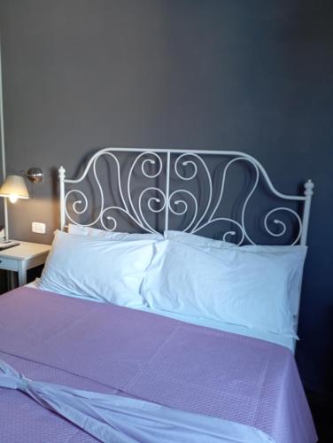 a bed with a metal headboard and white pillows at Peppinella Affittacamere in Cetraro