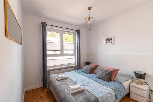 a bedroom with a large bed and a window at Apartament Chmielna Loft in Kraków