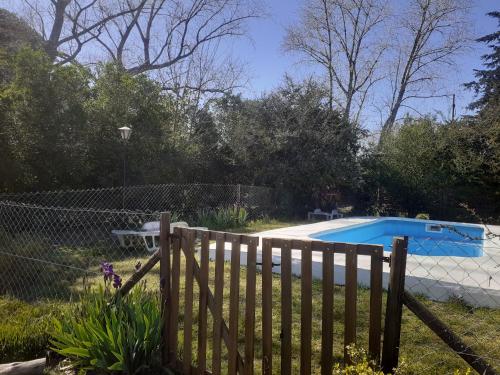 una valla de madera frente a una piscina en Cabañas Artemisa en Tandil