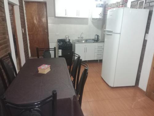 a kitchen with a table and a white refrigerator at Complejo Hatun Yaya in Mendoza