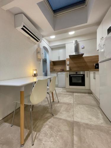 une cuisine avec une table et des chaises dans une pièce dans l'établissement Pt'i Cosy Cabestany - rénovée - La mer à 10 min, à Cabestany