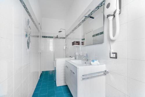 een witte badkamer met een wastafel en een spiegel bij Casa da Suite Compatta in Milaan