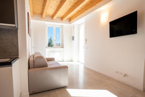 uma sala de estar com uma cadeira e uma televisão em Villa San Carlo em Arona