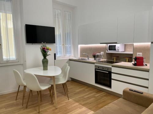 a kitchen with a table and chairs and a kitchen with a sink at MILA by The Blue Twins apartments Milano in Milan