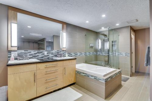 ein Badezimmer mit einer Badewanne, einem Waschbecken und einem Spiegel in der Unterkunft Lake Oswego Home with Covered Patio Near Portland! in Lake Oswego