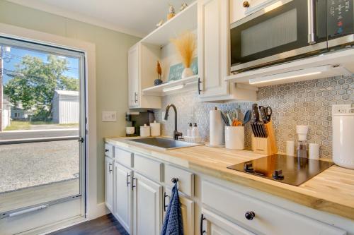 a kitchen with white cabinets and a sink and a window at Chincoteague Apartment with Deck Walk to Waterfront in Chincoteague