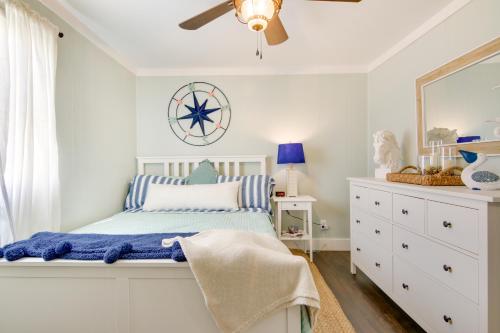 a bedroom with a bed and a dresser and a mirror at Chincoteague Apartment with Deck Walk to Waterfront in Chincoteague