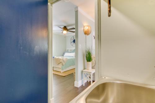 a bathroom with a bath tub and a bedroom at Chincoteague Apartment with Deck Walk to Waterfront in Chincoteague