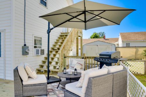 a patio with an umbrella and a grill at Chincoteague Apartment with Deck Walk to Waterfront in Chincoteague