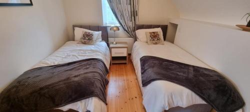 two beds in a small room with aermottermottermott at Bernie’s Place in Ballyliffin