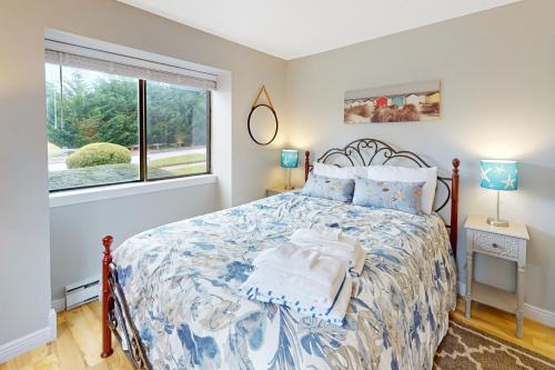 a bedroom with a large bed and a window at Sand, Shells & Sunsets in Brewster