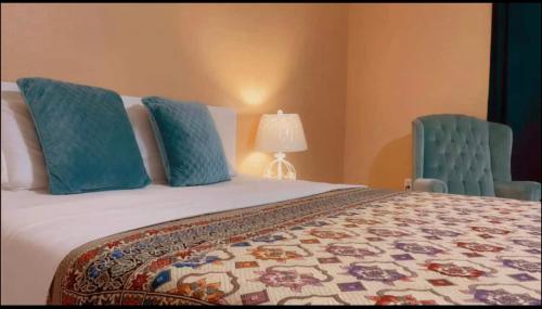 a bedroom with a bed and two blue chairs at Lux stay book 7 nights minimum and save in Jacksonville