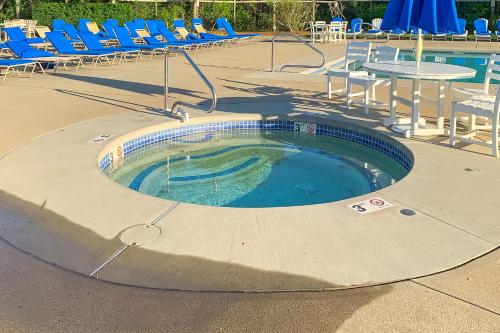 a small swimming pool with chairs and a table at Sand, Shells & Sunsets in Brewster