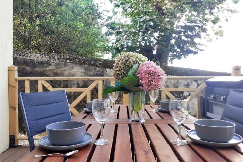 una mesa de madera con un jarrón de flores. en Nice flat 300 meters away from the beach - Biarritz - Welkeys en Biarritz