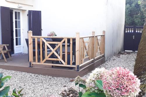 une terrasse couverte avec une clôture en bois et des fleurs dans l'établissement Nice flat 300 meters away from the beach - Biarritz - Welkeys, à Biarritz