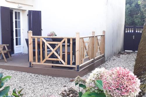 a porch with a wooden fence and flowers at Appartement Frias - 3 étoiles - Welkeys in Biarritz