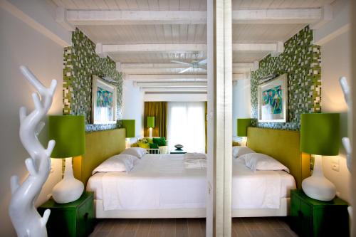 a bedroom with two beds and a mirror at Salvator Villas & Spa Hotel in Parga