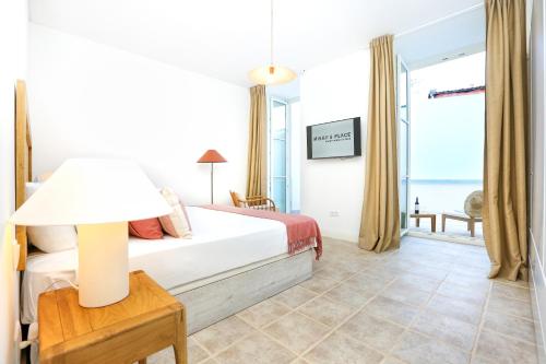 een slaapkamer met een bed en een tafel met een lamp bij Dolce Faro Niente Apartment in Faro