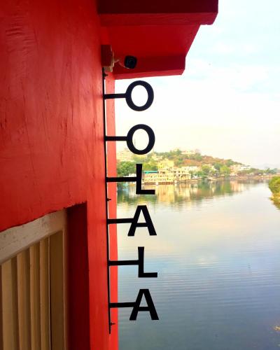 a red building with a view of a river at Oolala - Your lake house in the center of Udaipur in Udaipur