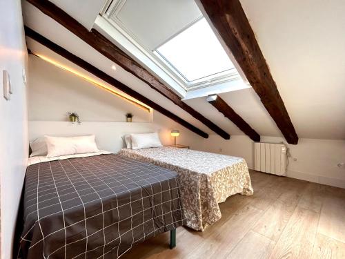 1 dormitorio con 2 camas y tragaluz en Malasaña Sky, en Madrid