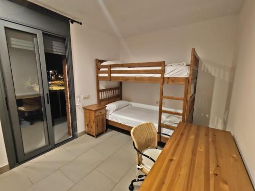 Una pequeña habitación con una litera y una mesa. en Apartamento nuevo en Sant Antoni de Calonge, en Sant Antoni de Calonge