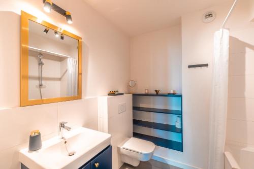 a bathroom with a sink and a toilet and a mirror at Apartament Chmielna Gold in Kraków