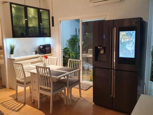 a kitchen with a table and a black refrigerator at Serene Home Stay in Bangalore
