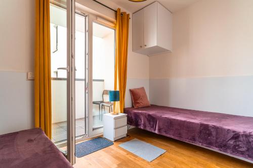Habitación con cama morada y ventana en Apartament Chmielna Gold, en Cracovia
