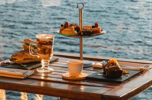 una mesa con un plato de repostería y un vaso de cerveza en El Faro Boutique Hotel & Spa by DON en Villa La Angostura