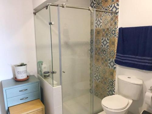 a bathroom with a toilet and a glass shower at Beautiful and cozy apartment in Villeta