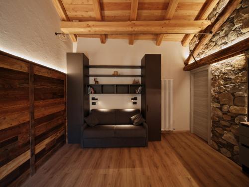 a living room with a couch and a stone wall at Appartamenti il bersaio Alloggio 4 in Sambuco