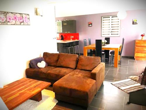 Una sala de estar con un sofá marrón y una mesa. en Villa marine, en Hirel