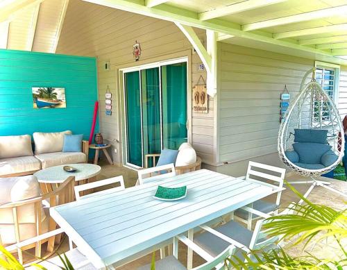 um pátio com uma mesa, cadeiras e um sofá em Duplex Green Paradise , piscine , accès mer 5mn em Le Diamant