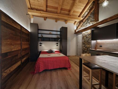 a bedroom with a bed in a room with wooden ceilings at Appartamenti il bersaio Alloggio 4 in Sambuco