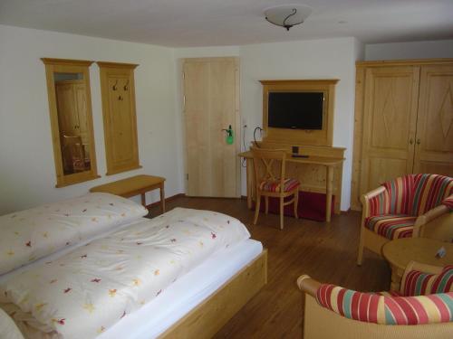 a bedroom with a bed and a desk and a television at Hotel Blumental in Mürren
