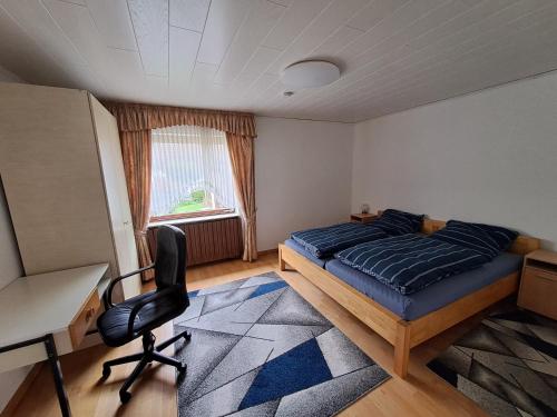 um quarto com uma cama, uma secretária e uma cadeira em Ferienwohnung in Dierdorf em Dierdorf