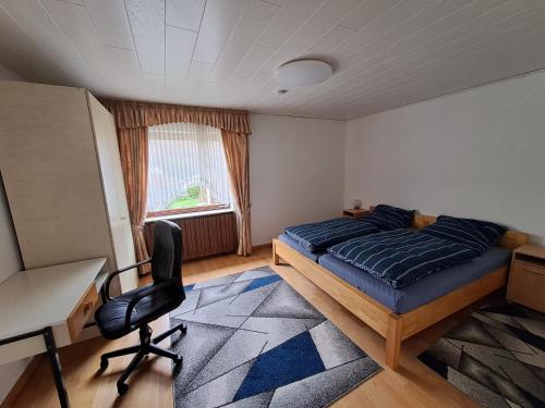 Schlafzimmer mit einem Bett, einem Schreibtisch und einem Stuhl in der Unterkunft Ferienwohnung in Dierdorf in Dierdorf