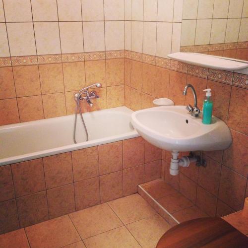 ein Badezimmer mit Waschbecken und Badewanne und Waschbecken in der Unterkunft Tündérpart Apartment in Eger