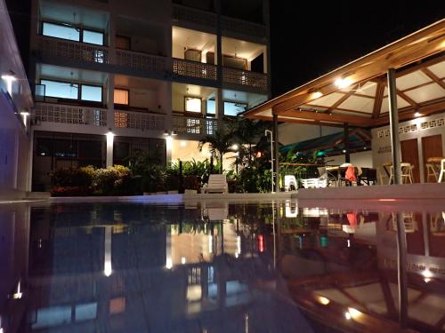 a swimming pool in front of a building at night at Morona Flats & Pool - 150 m2 in Iquitos