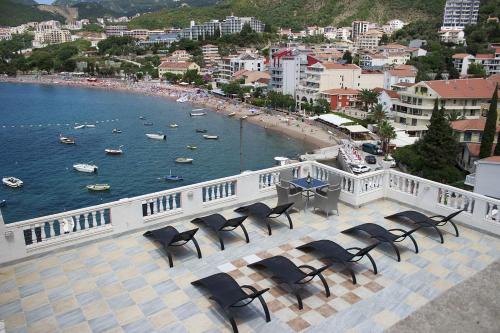 a balcony with chairs and a view of a beach at Hotel Kuč in Budva