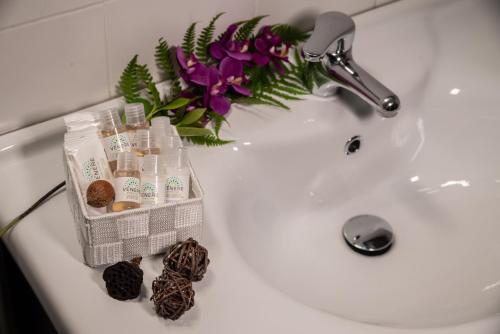 a white bathroom sink with a vase of flowers at Isa Center - Leonardo Accademy - MXP - Lakes in Sesto Calende