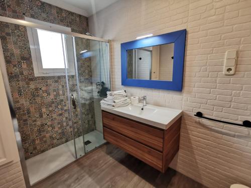 オリーバにあるCaseta en la playa de Olivaの洗面台と鏡付きシャワーを備えたバスルーム