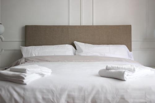 uma cama branca com duas toalhas dobráveis em Alójate en el corazón de Mendoza . Angélica Downtown em Mendoza